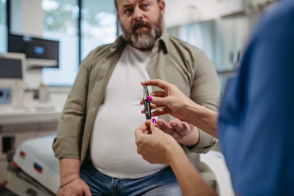 nurse checking man s blood glucose level using a f 2023 11 27 05 18 37 utc